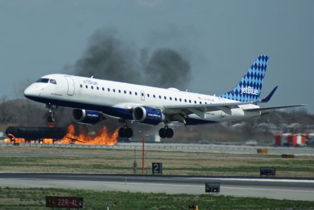 Embraer ERJ-190 (N183JB) - Jetblue ERJ-190 touching down while the JFK Fire Department trains in the background.