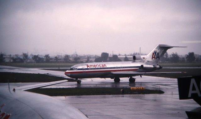 Boeing 727-100 (N1990) - KSJC - CN: 18446 LN: 123 First flight March 3rd, 1965, delv to American Airlines March 19th, 1965. Rainy San Jose day meant walking the terminals, the view is blocked inside as the jetways and other jets helped me almost miss this jet rolling off 30L in this late 1989-1990 color slide. This jet shows it flew with American its entire career, and a 727-1 at San Jose in the late 1980s was rare. Total luck I caught this brief moment in time at SJC.