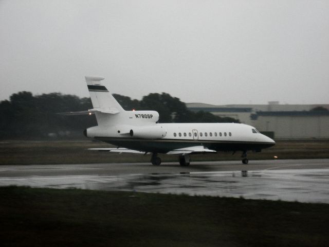 Dassault Falcon 900 (N780SP) - A Falcon 900 taking off from a wet runway 8 at KFXE. Taken from Alexandra, our "modernized" Douglas DC-3 operated by MFI (Missionary Flights International), which flew us to the Bahamas on our missionary school trip on 1/4/12. What wonderful weather for flying... :P