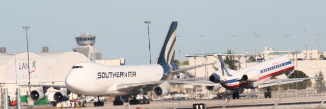 Embraer ERJ-145 — - American Eagle E145 landing on 9 with Southern Air 747-200 on taxiway parallel to 9. Shows how tiny the Embraer is...