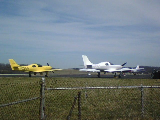 — — - Three Lancairs parked on main ramp at Washington County.  N18GG(yellow)-Lancair Legacy 2000  N5ZQ(silver and white)-Lancair 320  N515RB(maroon in background)-Lancair 320
