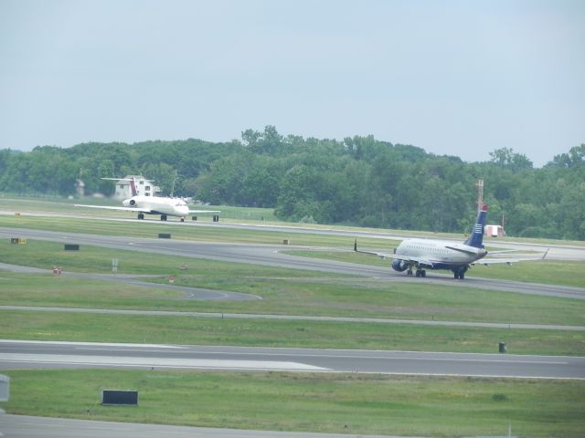 Embraer 170/175 (N811MD) - A US Airways Embraer 175 taxis to the runway to take off behind a Delta MD88 at Albany International.