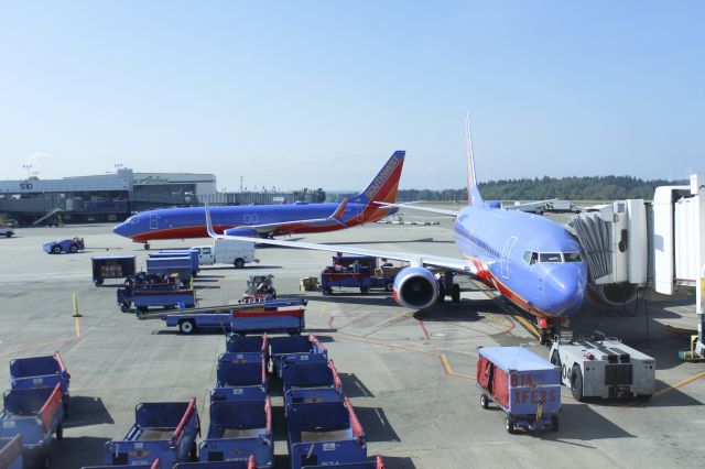 Boeing 737-800 (N8303R) - 050714 push back at B gates. SWA B737 N8310C getting loaded.