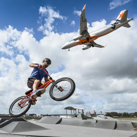 Airbus A320 (VH-VFF) - BMX bike jumping while a Jetstar A320 passes by on approach. 