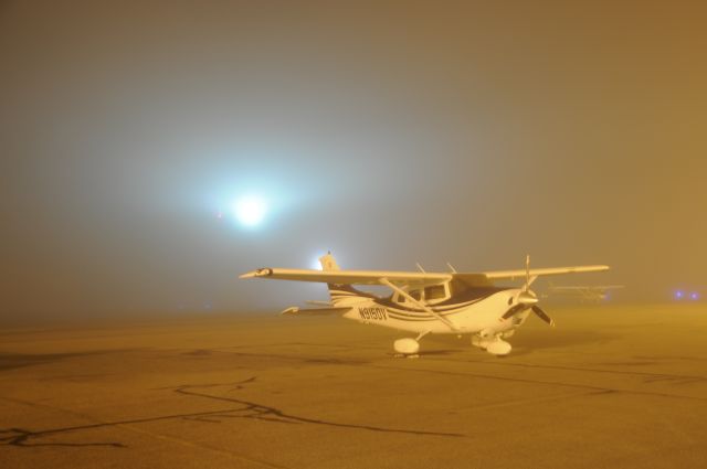 Cessna Skylane (N915DV) - Foggy Morning (Airport rotating beacon in background)