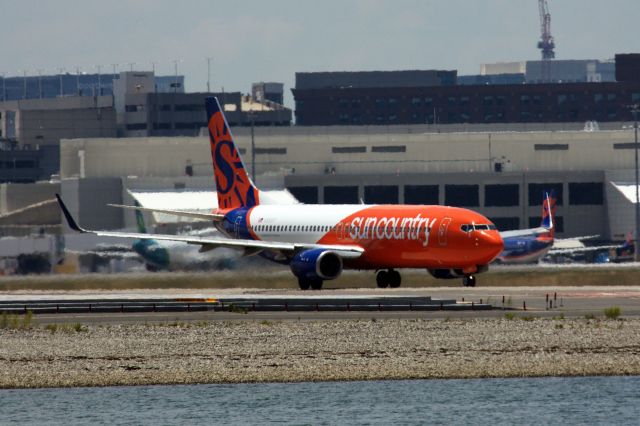 Boeing 737-800 (N830SY) - Sun Country B738 (N830SY) in new livery taxi's for departure while a second Sun Country in old livery remains at the gate on 6/21/20.