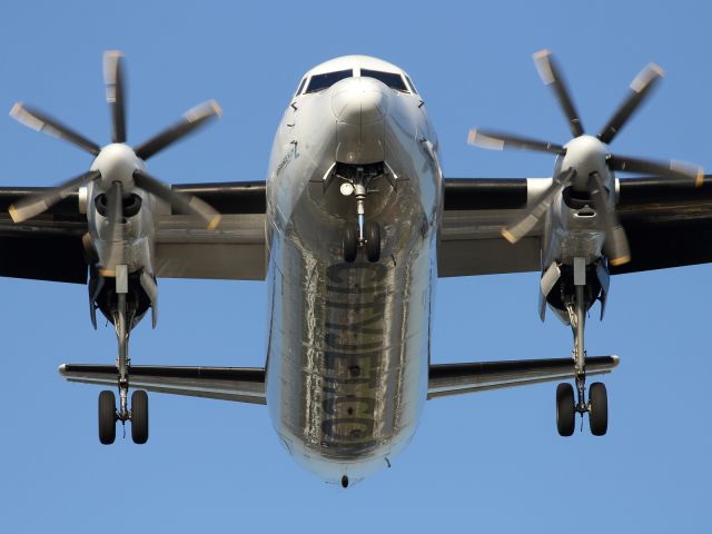 — — - The turboprop powered Fokker F-50 on approach to London City Airport.