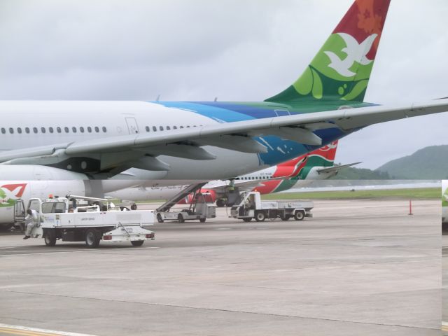 Airbus A330-300 — - A tale of two tails.  Following on from the KQ photo, Air Kenya makes her way behind HM019 Air Seychelles, which had only just arrived a few minutes earlier to the international airport in the Seychelles.