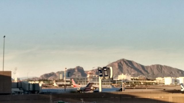 — — - Here is a photo from the east-side of Phoenix Sky Harbor Airport, Terminal 4. Some American Eagle jets are parked at the gates, and in the background is the Camelback Mountains. 