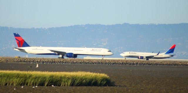 BOEING 757-300 (N592NW) - "Hi, Daddy" .. The smaller Delta B737, lands while the 757 is taxiing out for take off