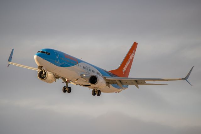 — — - Sunwing fights the gusty winds on short final to 17L in CYYC.