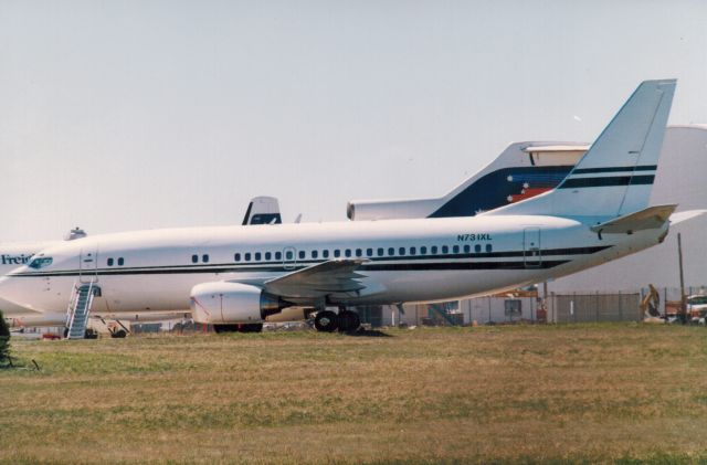 BOEING 737-300 (N731XL) - Melbourne Tullamarine 1989.  A B727 of the now defunct Ansett Airlines sits in the background. Ansett went broke in 2001. 