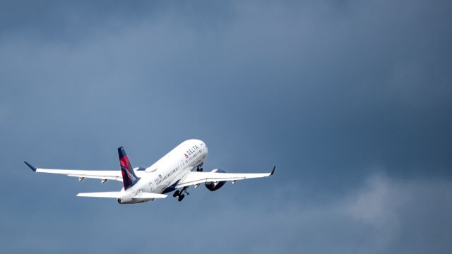 Airbus A220-100 (N106DU) - Delta A220 retracting its gear as it ascends towards a vast overcast sky.