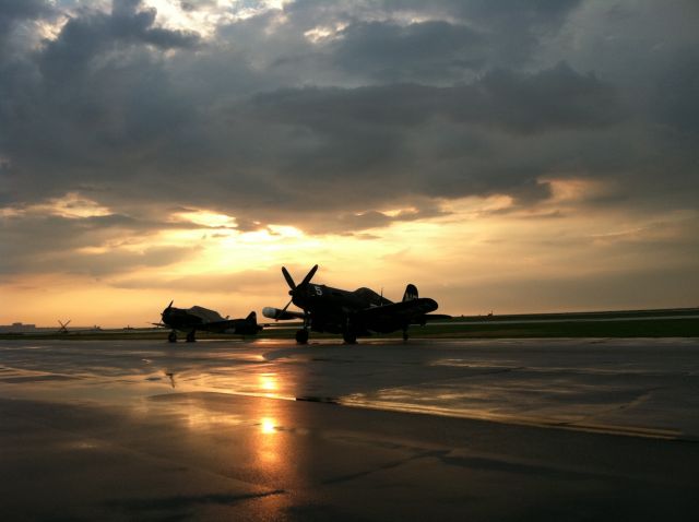 — — - F4U-5 Corsair and T-6 SNJ sit on the ramp after the Cleveland National Air Show on September 3, 2012.  The remnants of Hurrican Isaac had just blown threw before the sun set on another great air show.