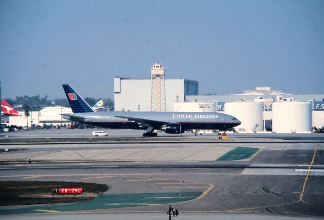 Boeing 777-200 (N790UA) - KLAX - Imperial Hill view area - Hard to believe this was January 1999 and this 777 was only about 1-year old when this was taken. Boeing 777-200 CN: 26943 92- last shows flying with Omni Air Intl, but now stored 2016. This dusty slide was taken during a 3 day weekend and Mark and Mike Durbin and my co worker Craig Curtis( ex AA employee-SJC) took a photo run to LAX from the SJC area....