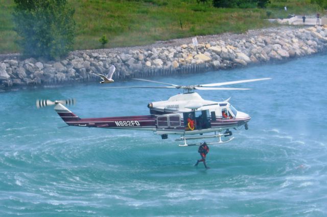 Bell 412 (N682FD) - Diver away… A Chicago Fire Department diver dropping into Lake Michigan behind the McCormick Center. Their Dive Team and Air-Rescue units demonstrated their capabilities during the International Association of Fire Chief’s Conference in Chicago, Illinois on Aug 26, 2010. Diver’s located and retrieved a rescue mannequin before hoisting into the helicopter. The rotor-wash kicked up the water causing a slightly blurred effect.