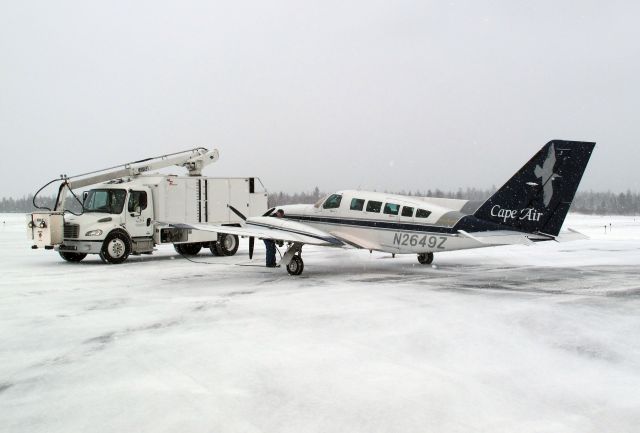 Cessna 402 (N2649Z) - De-icing before take off. Hard working pilots in a challenging weather environment, summer and winter.