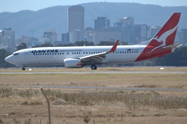 Boeing 737-800 (VH-VXA) - On taxi-way heading for Terminal 1, after landing on runway 23.Part of the Adelaide city skyline can be seen in the background. Thursday 4th April 2013.