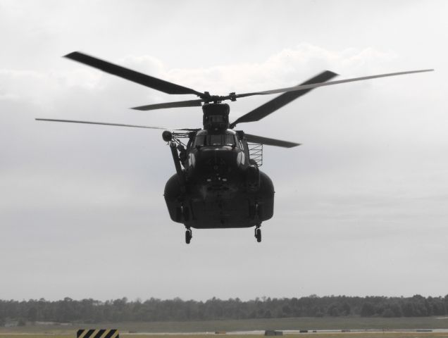 0603767 — - MH-47G lifting off the helicopter pads to reposition for departure on an overcast day.