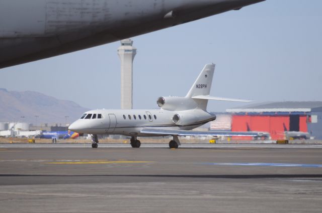 Dassault Falcon 50 (N28PH) - A old school Falcon 50 taxing for Runway 35 departure. KSLC tower in the background and under the tail of a C5 Super Galaxy. br /Best viewed in full! 