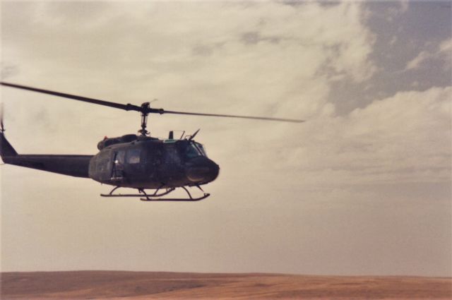 Bell UH-1V Iroquois — - 3/91 on an unnamed roadheading east from Al Salman, Iraq towards Kuwait. My team was set up on the only high ground in the area, security and overwatch for the convoys heading east with supplies for the units operating in the area. This chopper is 200' above the highway, but eye level with my position.