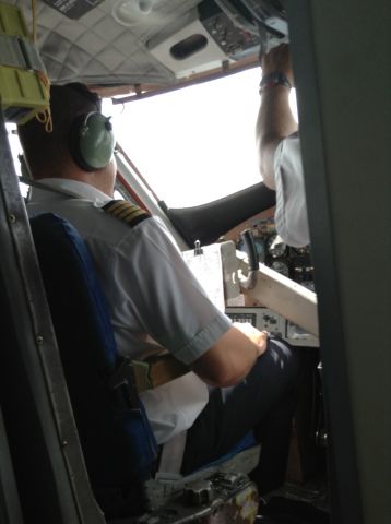 — — - The pilot sits at the ready for a hop over to Praslin on this packed Twin Otter flight.