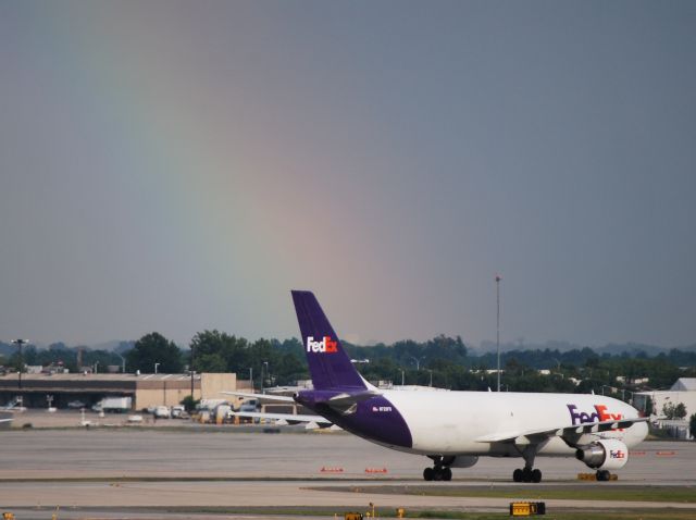 Cessna Citation Excel/XLS (KCLT) - A FedEx A300 taxiing while a rainbow looms from a storm to the southeast of the airport - 7/19/12