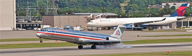 McDonnell Douglas MD-80 — - American touching down on runway 30L, with a Delta A330, out for maintenance, in the background.