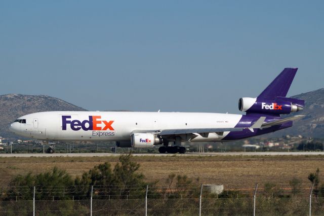 Boeing MD-11 (N584FE) - FedEx MD11 taking off runway 03L on a warm day in Athens. A very welcome sight!