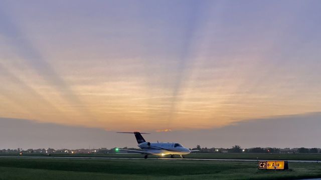 Cessna Citation CJ2+ (N358WC) - N358WC, a 2006 Cessna 525A CitationJet CJ2+, taxiing to the FBO with the sunset poking through the clouds in the background. 6/15/22. 