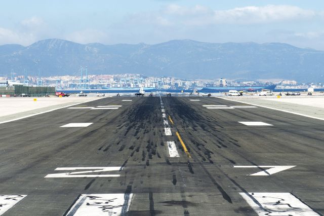 — — - Lined up on 27 for departure to EGHI - slight delay with vehicles crossing runway due to traffic lights being on GREEN! Amazing sight with Gibraltar Harbour and large ships beyond the end of the runway.