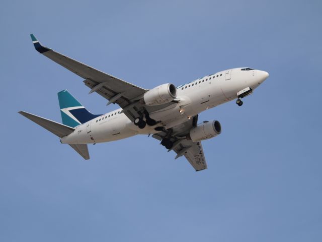 Boeing 737-700 — - One of many WestJet 737s comes in for a landing at CYWG.