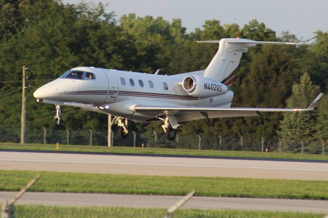 Embraer Phenom 300 (N402QS) - On approach to 28R. Photo taken from Marriott Residence Inn parking lot on Sawyer Rd.  300mm lens. 