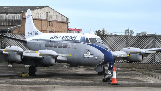 Hawker Siddeley Heron (G-AORG) - De Havilland DH114 Heron - box for aircraft type would not accept this. Behind aircraft old Air UK prev Jersey Airlines Hangar condemned 25 years ago ... Island Life
