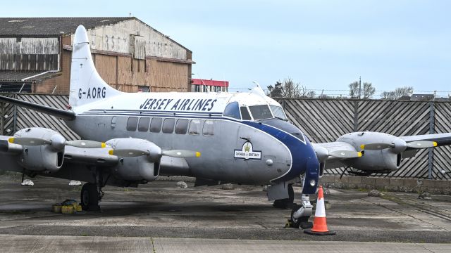 Hawker Siddeley Heron (G-AORG) - De Havilland DH114 Heron - box for aircraft type would not accept this. Behind aircraft old Air UK prev Jersey Airlines Hangar condemned 25 years ago ... Island Life