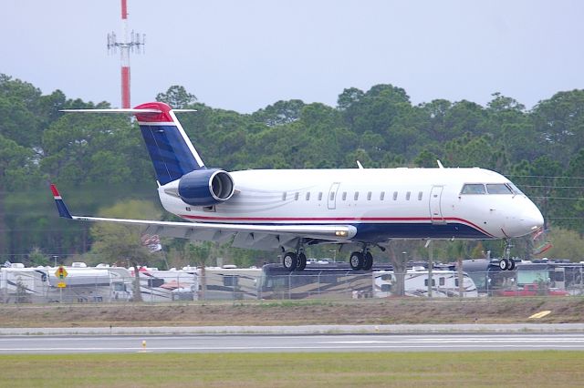 Canadair Regional Jet CRJ-200 (N570ML) - Formerly of Mesa Airlines, this Stewart Haas Racing CRJ still wears the base livery of US Airways Express. Seen here landing 7L during the Daytona 500.