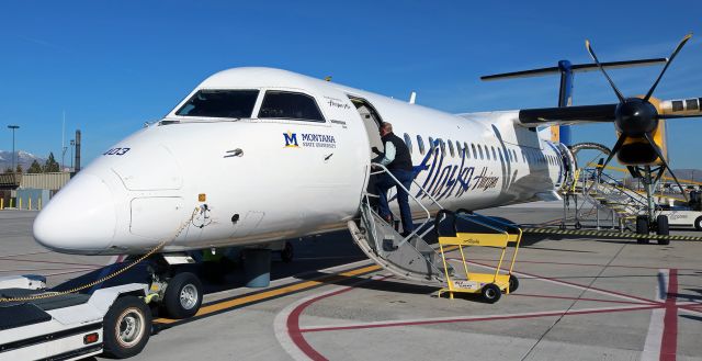 de Havilland Dash 8-400 (N403QX) - A passenger boards QXE's N403QX, the Montana State University "Bobcats" collegiate liveried Dash 8, for a flight to Portland (KPDX).