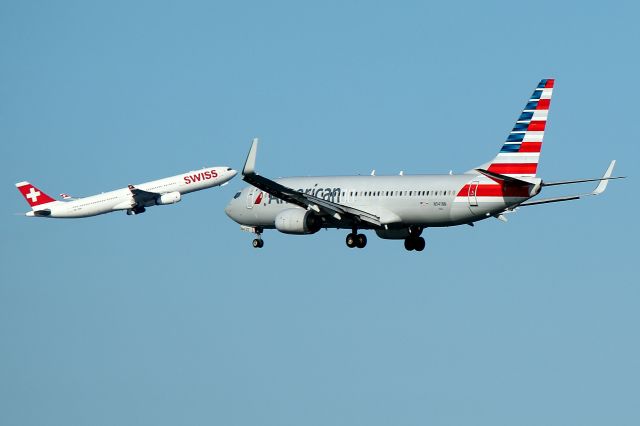 Boeing 737-800 (N941NN) - AA 1430 arriving from Dallas on 4R as Swiss 55 Kilo departs for Zurich on 15R