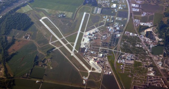 — — - Sioux Gateway Airport (KSUX); serving Sioux City, Iowa; is viewed here in this click taken back in 2013 (seven years ago).br /To orient the viewer, Runway 13-31 is the long runway that goes from upper left to bottom middle. The other runway going from top center to the center of the pic is 17-35.br /An interesting note .... The very famous crash of UA Flt 232 (7/19/89) occurred here at Sioux City. The fabulous team of pilots who struggled and strained to get their heavy DC-10 down on the ground here had fought to get their crippled jet lined up to land on 31-13 but as it careened in circles in the Iowa sky it ended up aligned with a closed runway, 22-4, and because they had no other choice, it was on Runway 22 where the pilots managed to get Flt 232 down. In my photo here, which I snapped exactly 24 years after the crash, I believe that the remnants of Runway 22-4 are the faded diagonal running from near the top center downward toward the left middle edge. In my photo, the "4" portion of 22-4 still appears to be paved for a short distance while the "22" end of 22-4 has been built over and is now occupied by the two blue-roofed buildings of an Air Museum. The arrow-shaped intersection that today is the museum's parking lot was ... back on July 19, 1989 ... the start of Runway 22 which was marked with an "X" designating that it was closed. Also of interest, there are two aircraft (barely visible) sitting out on display on what was once the first few feet of Runway 22 (at the exact spot that Flt 232 touched down), and one of those two aircraft is an old Armstrong-Whitworth AW-660 Argosy (G-BFVT).