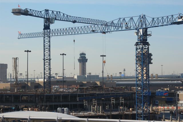 — — - 111113 Centrer tower framed by the tower cranes on the Term A parking structure job.