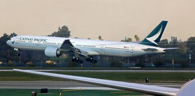 BOEING 777-300ER (B-KPR) - Vapor trails caused by the extended wing flaps can be seen streaming behind Cathay Pacific's B-KPR, a B777-367(ER), as it flares out to land at the end of a flight from Hong Kong (HKG). 