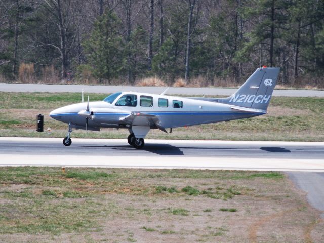 Beechcraft Baron (58) (N210CH) - Arriving on runway 20 - 3/18/09