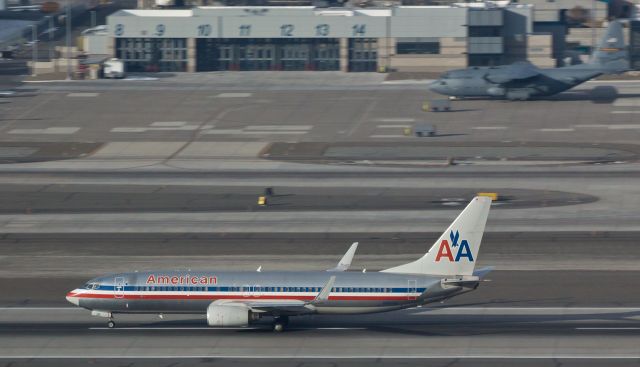 Boeing 737-800 (N851NN) - This snap taken thru the blue shades of Reno Tahoe Internationals control tower shows Americans N851NN rolling past the Nevada Air Guard "High Rollers" ramp and Fire Department facilities while accelerating down runway 16R.