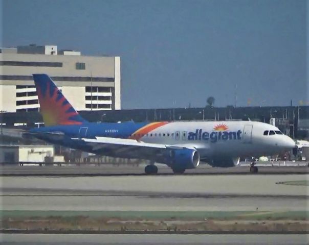 Airbus A319 (N335NV) - An Allegiant Airbus A319-111 painted in the new livery just seconds after touchdown.