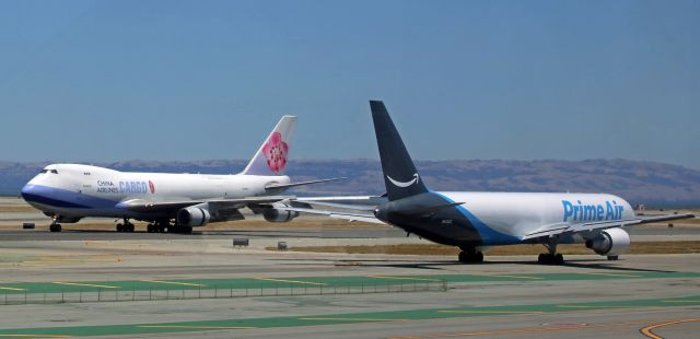 BOEING 767-300 (N443AZ) - Two heavies pass each other as Prime Air's B763 N443AZ is taxiing out for departure to Wilmington Air Park (KILN-Ohio) while China Air Cargo's B744 is reversing thrust during its deceleration roll.