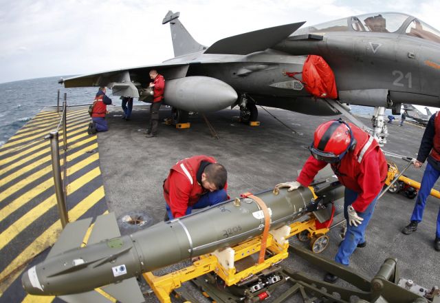 — — - Red jacket ordnance crew place bombs under a Rafale fighter jet aboard Frances Charles de Gaulle aircraft carrier on mission in the Gulf, January 28, 2016. (Photo by Philippe Wojazer/Reuters)