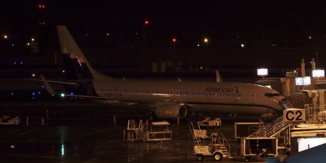 Boeing 737-800 (N916NN) - It was a messy, messy night, but here is a snapshot of something that has not been seen at Reno Tahoe International since 1999 ... the ROA livery on a passenger aircraft at a KRNO gate.  On the night of December 13, 2015, for the first time in 16 years, a pax jet wearing Reno Air paint was back home in Reno ... and, perhaps quite appropriately, the snow had just started falling ... and is just beginning to be visible (right below the snow-covered mountains) on the tail end of Americans N916NN, the Reno Air heritage schemebird.  So, despite having to click this shot from the top of the parking garage at night thru falling snow, I am extremely pleased to be able to say I caught the Homecoming of Reno Air.  