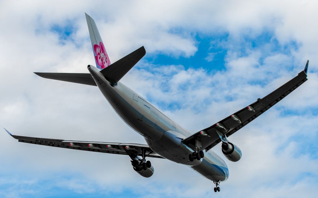 Airbus A330-300 (B-18359) - Photographed on short finals for Runway 02 at about 300ft AGL, about to cross Ryans Road and the DVOR. The aircraft was holding about 10 drift to the left due to the westerly crosswind. The pilots didnt yaw right before touchdown, so the gear got a smokey hammering!