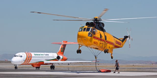 Sikorsky Sea King (N612CK) - Croman's N612CK, a Sikorsky S-61 Sea King, lifts off to return to making water drops at the North Fire.  The ground agent is watching to insure that the Bambi Bucket is not entangled in any manner.