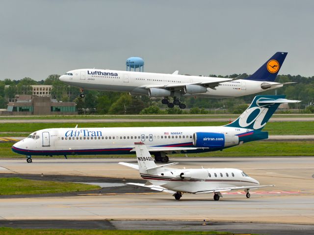 Cessna Citation Excel/XLS (N594QS) - A rare combination at KATL. Net Jets Cessna 560XL awaiting take-off. AirTran B717 just starting run for take-off. Lufthansa A340-300 landing.